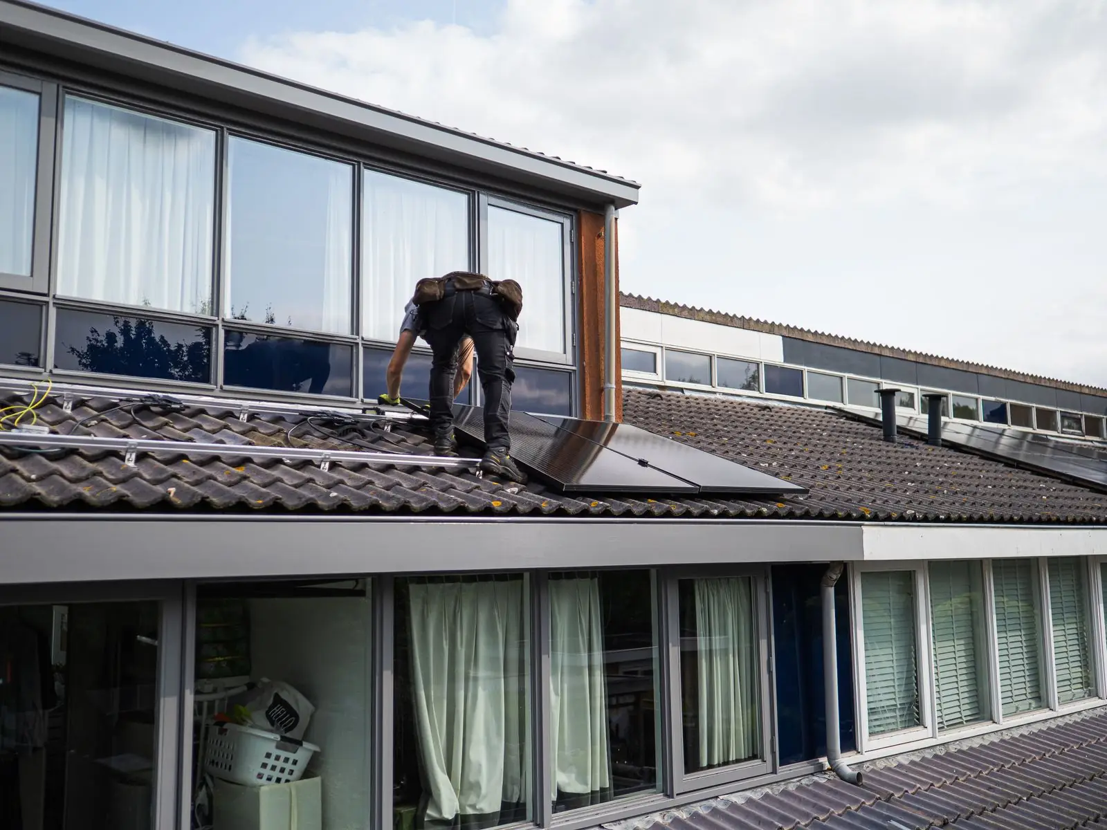 Técnico instalando painéis solares em telhado