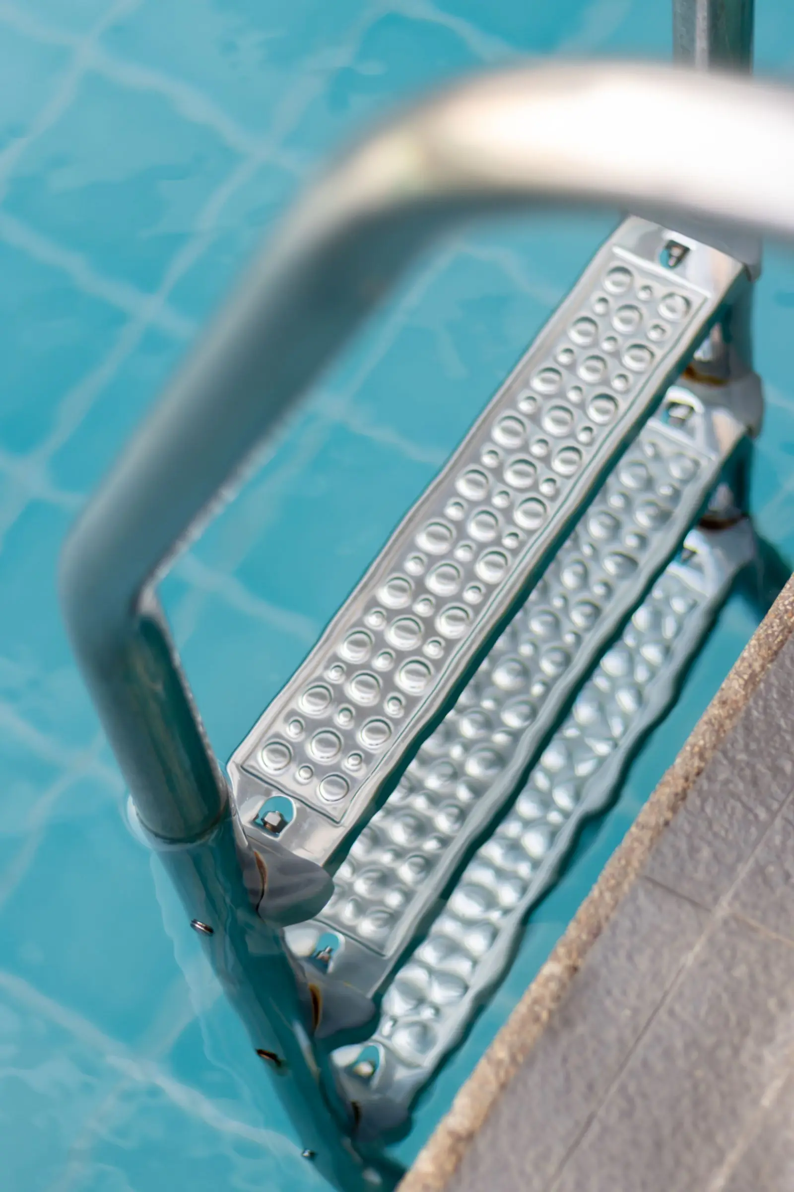 Escada dentro de piscina com água transparente