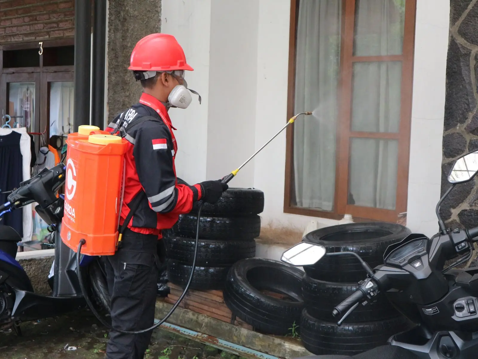 Profissional com equipamento de proteção aplicando produto