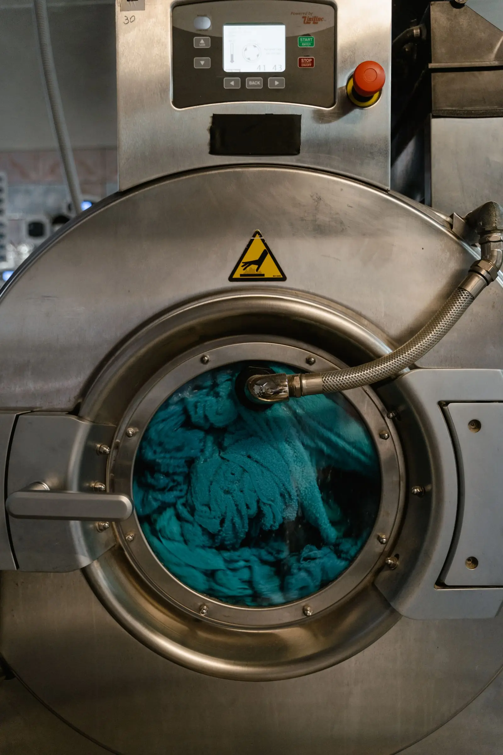 Tecido azul girando dentro de máquina de lavar
